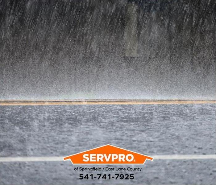 Heavy rain falls on a flooded street.