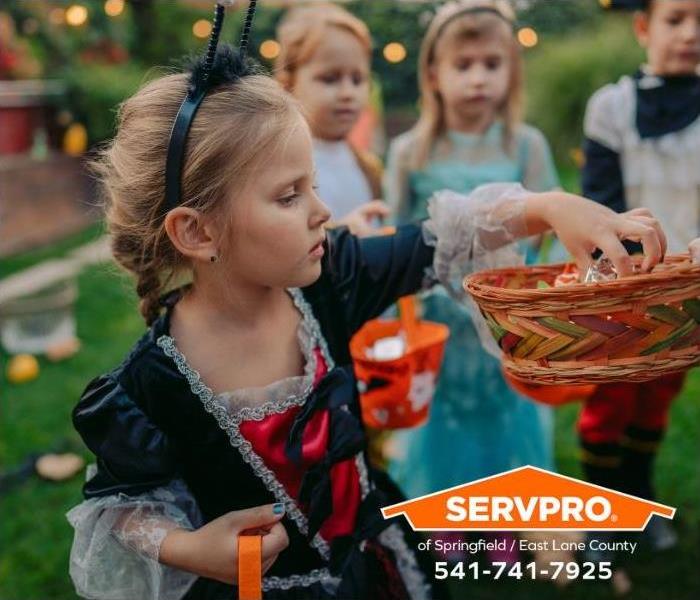 Trick-or-treaters are getting candy from a neighbor.