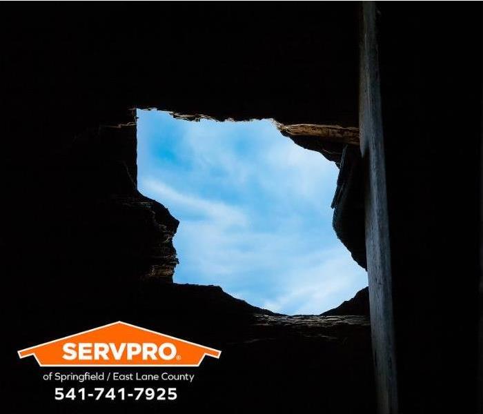 Blue sky can be seen through a storm-damaged roof.