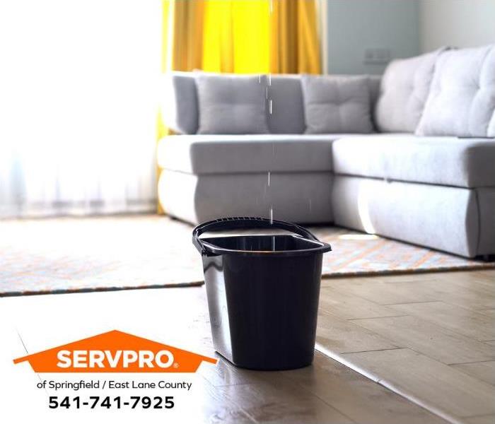 A bucket catches water dripping from a water leak in the ceiling.